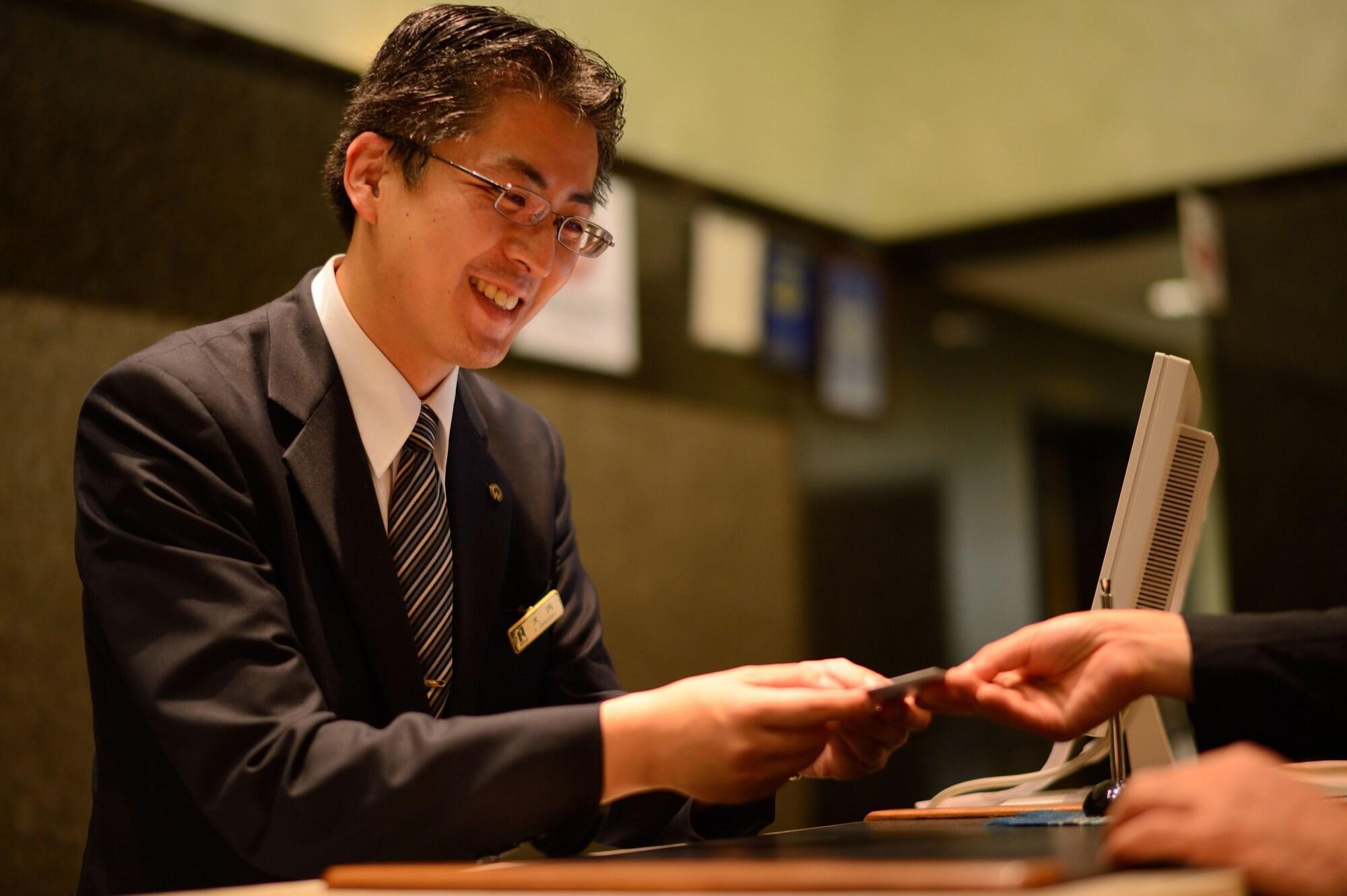 Royton Sapporo Hotel Exterior foto A hotel clerk at the front desk
